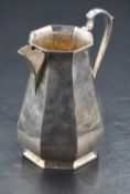 An Edwardian silver milk jug, of octagonal baluster form with scrolled handle and short swept spout,