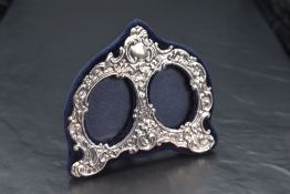 A Queen Elizabeth II silver-mounted double photograph frame, of arched and shaped form, the mount