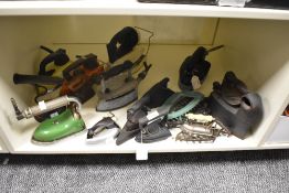 A collection of fifteen vintage and antique irons and trivets, including flat irons, gas and early