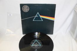 A VG/VG copy of Pink Floyd's DSOTHM with stickered sleeve and one poster