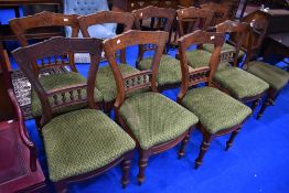A set of ten Victorian mahogany dining chairs having short spindle backs, over stuffed seats and