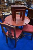 A modern laminate circular dining table and four chairs, sold with similar nest of three tables,