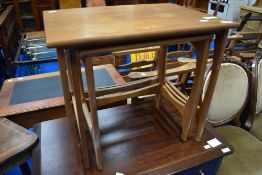 A vintage teak laminate nest of three tables of stylised form, approx W57 D41 H51cm, stamped to base