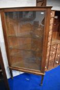 An early 20th Century oak corner display, having adjustable glass shelves (corner chip to one)