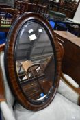 A vintage grain effect oval wall mirror, approx 83 x 54cm