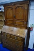 A 19th Century golden oak bureau having shell and moth designs , brass hinges to bookcase door and
