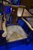 A traditional stained frame rush seated armchair