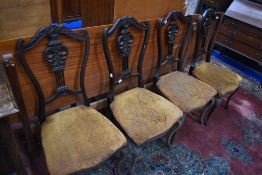 A set of four Victorian mahogany salon/dining chairs having shaped backs and upholstered seats