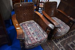 A pair of early Ercol armchairs having leather lattice work backs and sides, leathered arms and