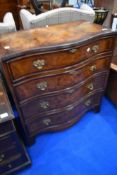 An early 20th Century walnut serpentine front chest of four drawers