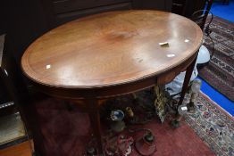 An Edwardian mahogany Sheraton style centre table of oval form having satinwood inlay decoration