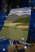 A modern rural crafts woolwork wall hanging depicting sheep in country landscape, with hanging rail,