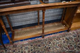 A modern hardwood console table having glass top and cane undertier, approx dimensions W133 D41