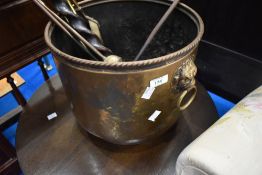 A brass coal bucket and selection of fire tools