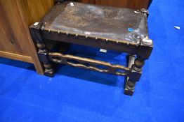 A Priory style leather seated footstool, width approx. 57cm