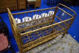 A vintage wicker cot, dimensions approx L132cm W60cm H91cm