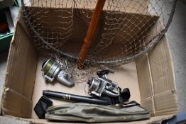A mixed box containing fishing tackle 2 spinning reels a wooden handled landing net, floats and a