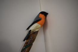 A spiral carved walking stick with bullfinch mounted on top