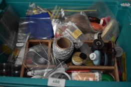 A plastic box containing a quantity of fly tying equipment