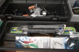 A tool box containing some unused fishing tackle and four large sea fishing reels in good condition