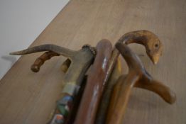 A Selection of 8 walking sticks one with an antler handle and another carved into a pheasant head