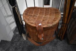 A large vintage wicker fishing creel and folding leather topped stool