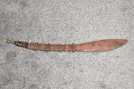 A Nigerian Takouba type Sword.leather grip with brass pommel, leather scabbard with leaf shaped