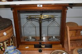A cased set of vintage brass balance scales, displayed within a glazed mahogany case, dimensions