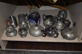 A collection of pewter and similar, including planished teapots and jugs.
