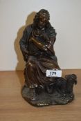 A modern bronze effect depiction of shepherd holding lamb.