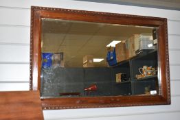 A vintage rectangular bevelled glass mirror, within wooden frame with beaded edge.