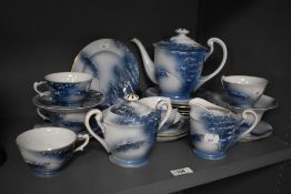 A Japanese Lithopane porcelain tea service, having off white ground with blue foliate decoration.