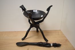 A primitive African hardwood bowl on folding tripod stand & spoon of matching design