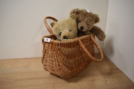 A woven wicker basket, a vintage teddy bear and a modern teddy.