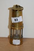 A miniature replica brass miners lamp.
