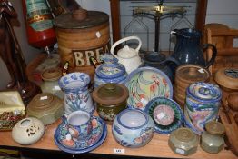 A collection of terracotta studio pottery with blue glaze and fish, fruit and floral designs, a