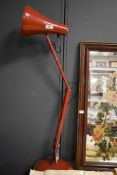 A vintage red Anglepoise table lamp.