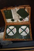 A traditional 'Optima' wicker picnic basket with plates, cutlery and lunch boxes.