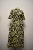 A 1940s yellow and black Paisley cotton house coat, having button to collar, three pockets and tie