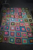 A vintage bed throw, using predominantly 1960s fabrics and backed in slightly older cotton striped