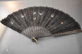 A Victorian fan of black gauze like fabric, with lace overlay and hand painted birds and