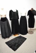 A mixed lot of vintage clothing, to include two velvet dresses and three skirts, mixed sizes, styles