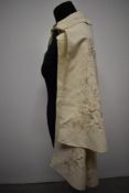 A 1920s cream childs cape, having hand worked silk embroidery.