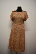A vibrant floppy cotton early 1940s day dress, having vibrant pattern and contrasting edged collar