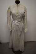 An early 20th century cotton chore dress, having print of blue stripes and circles, Broderie Anglais