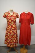 Two vintage dresses, to include bright sunflower print cotton dress and 1950s red pleated dress.