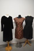 Three vintage 1960s dresses, including copper brocade dress and black velvet dress.
