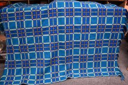 A large blue, green, black and white Welsh wool blanket, measures approx 94 by 74 inches.