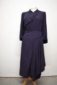 An unusual 1940s navy blue crepe day dress, having diagonal button fastening to bust, with purple