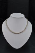 A string of graduated cultured pearls with a white metal and marcasite clasp, and a silver rope